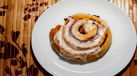 Cinnamon roll on a white plate Stock Footage 31821201
