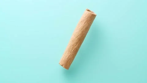 Cinnamon stick rotating on blue background Stock Footage 145970997