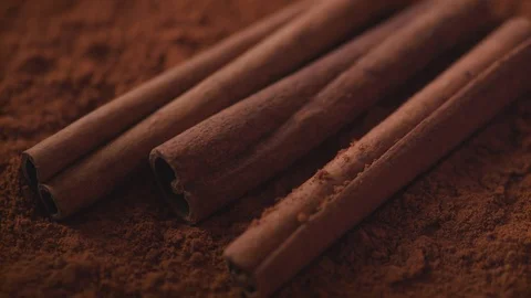 Cinnamon sticks falling into cinnamon powder. Slow Motion. Stock Footage