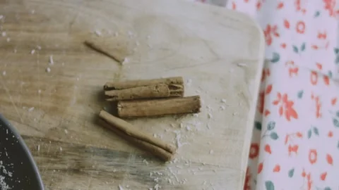 Cinnamon sticks isolated on a rustic holiday cutting board Stock Footage 342128158