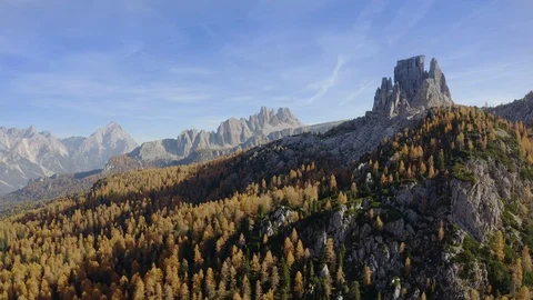 Cinque torri surrounded by a forest of orange Larches, Dolomites Stock Footage 129900629