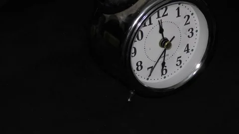 Circle of the alarm clock on the black circle rotating in rounds Stock Footage 111274057