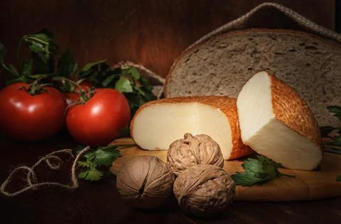 Circle of cheese on a cutting board in a rustic style Stock Photos
