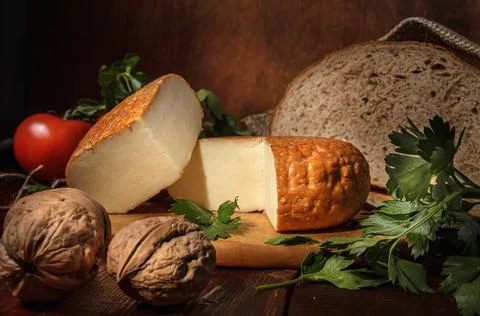 Circle of cheese on a cutting board in a rustic style Stock Photos