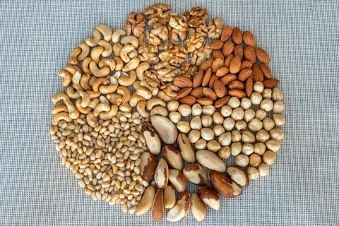 A circle of different nuts on linen fabrics, closeup Stock Photos