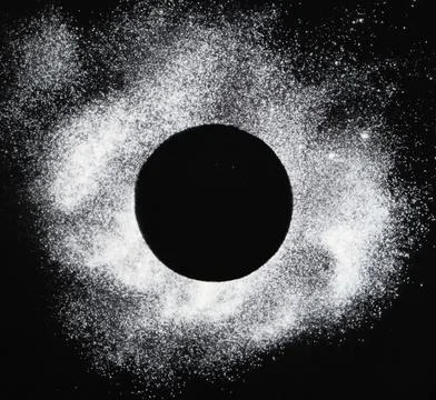 A circle of flour on a black background with space for text. Stock Photos