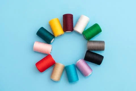 A circle in the form of a flower, colored spools with sewing threads as a Stock Photos