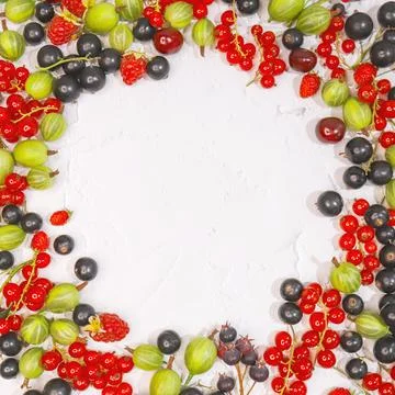 Circle frame of assorted wild fresh berries isolated on background. Stock Photos