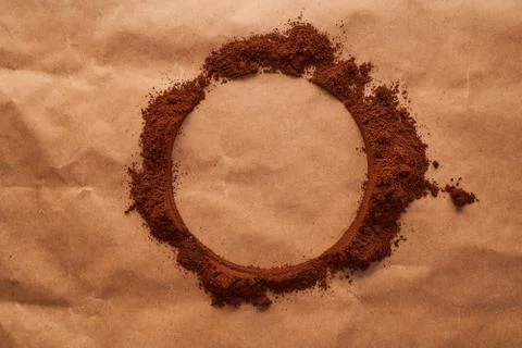 A circle of ground coffee on a brown background. Place to insert a slogan or Stock Photos
