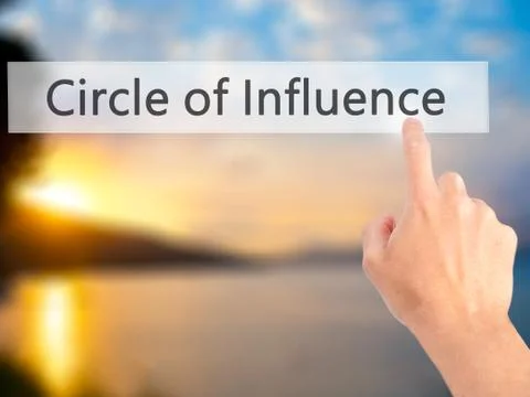 Circle of Influence - Hand pressing a button on blurred background concept on Stock Photos