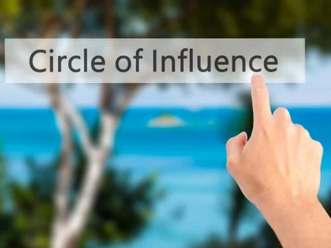 Circle of Influence - Hand pressing a button on blurred background concept on Stock Photos