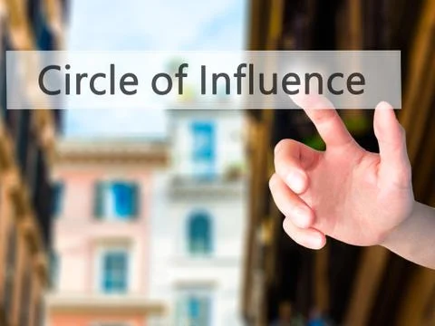 Circle of Influence - Hand pressing a button on blurred background concept on Stock Photos