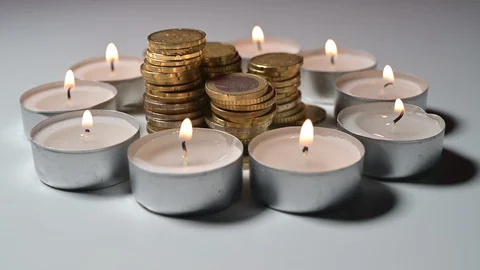 Circle made of burning candles with a stack of coins inside Stock Footage 129468974