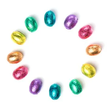 Circle made of chocolate easter eggs wrapped in multi colored foil on white Stock Photos