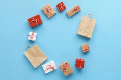 Circle made of gift boxes and shopping bags on blue background. Stockfoto's
