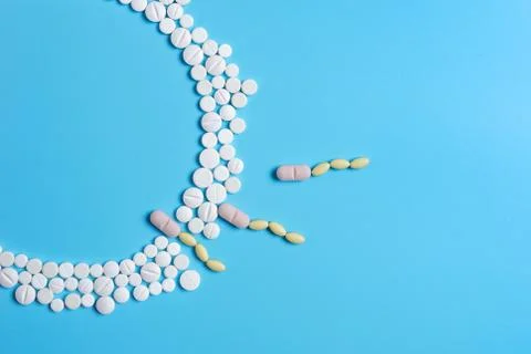 The circle is made up of white tablets on a blue background Stock Photos