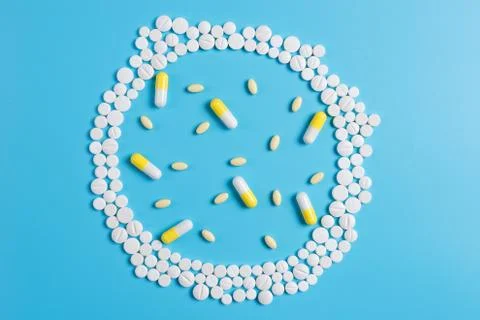 The circle is made up of white tablets on a blue background Stock Photos