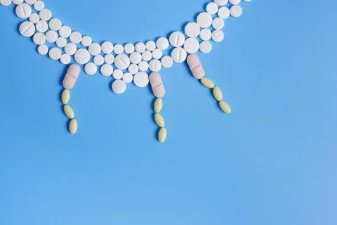 The circle is made up of white tablets on a blue background. Stock Photos