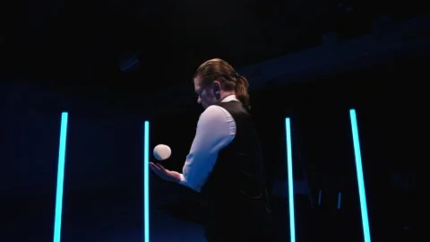 Circle movement camera around professional circus performer juggling white balls Stock Footage 147123716