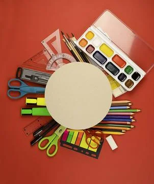 A circle on a red background with clerical school goods around. Stock Photos