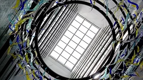 Circle shaped art decoration at the light-well viewed directly below Stock Footage 247450754