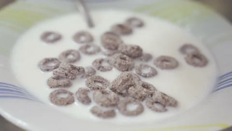 Circle shaped whole grain cereal falling into wooden bowl Stock Footage 239066544