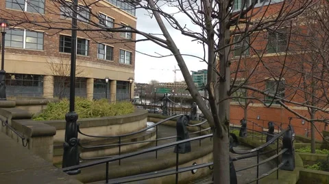 Circle of steps leading between office blocks leading to quayside and river. Stock Footage 1101929