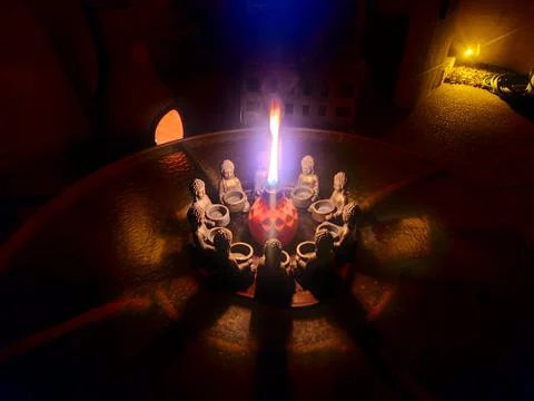 Circle of stone Buddhas with flame and shadows Stock Photos