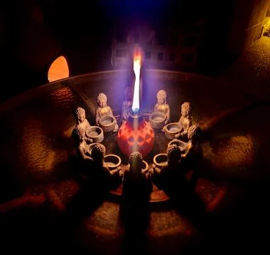Circle of stone Buddhas with flame and shadows Stock Photos