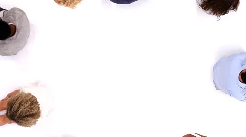 Circle of young people in white studio looking up at camera shot from above. Видео 32959613