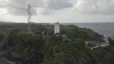 Circling aerial pulls back to reveal lighthouse on northeast tip of Trinidad Stock Footage 261925126