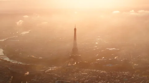 Circling aerial shot of the Eiffel tower backlit by the sunrise Stock Footage 291675436