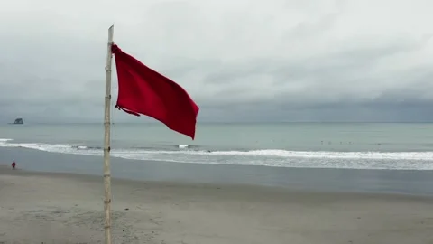 Circling around a red flag on the beach alongside a lifeguard post Stock Footage 146341981