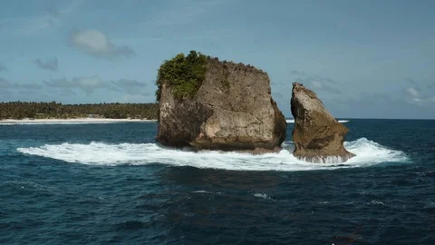 Circling arround a rock in the ocean while waves are crashing Stock Footage 103542540
