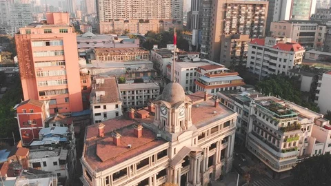 Circling the building with the tower clock. On the steeple hangs a Chinese flag. Stock Footage 102476444