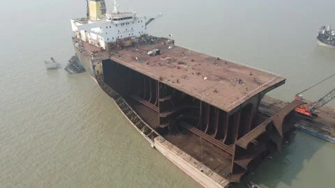 Circling a large damaged ship at a ship breaking yard Stock Footage 327167782