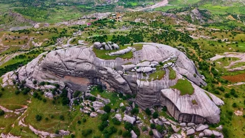 Circling a Massive Rock Formation Above a Dramatic Green Valley Stock Footage 341271430