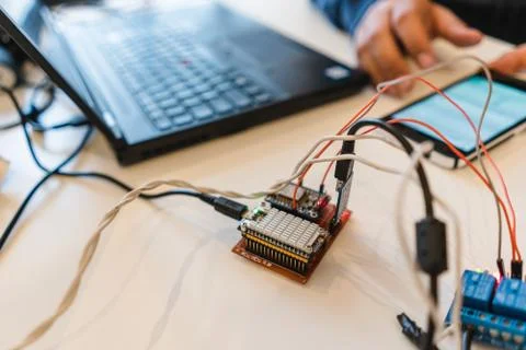Circuit board connected with IBM notebook and smartphone in background Stock Photos