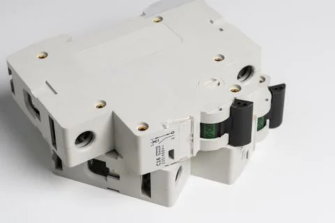 Circuit breakers lie on a white table. Stock Photos