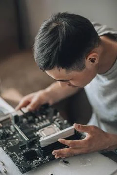 Circuit Expertise : With a steady hand, a computer engineer carefully secures a Stock Photos