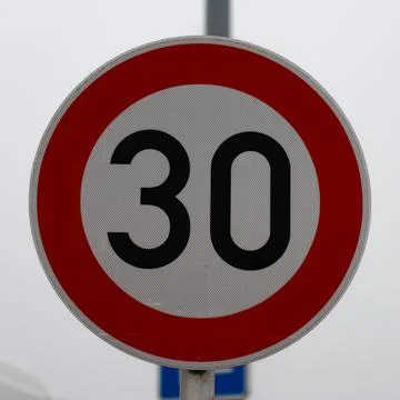 Circular 30 speed limit traffic sign on pole Stock Photos