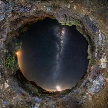 Circular 360 panoramic view of starry night sky with milky way and lighthouse Stock Photos