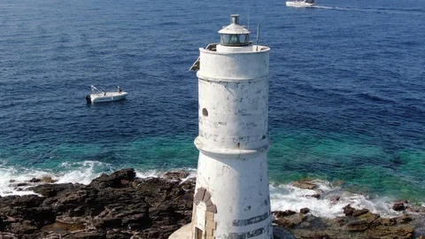 Circular aerial shot at the lighthouse on the coast of Sardinia Stock Footage 115437228
