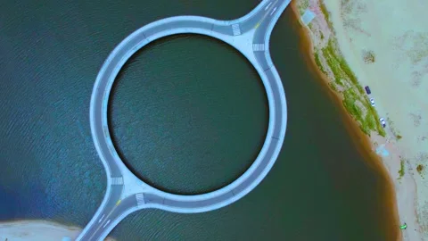 Circular bridge connects sandy banks over green water, drone footage, top-d.. Stock-Footage 341970362