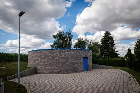 Circular drinking water storage building with blue door Stock Photos