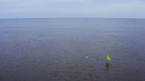 Circular drone flight. Baltic Sea landscape with Fishing net marking pole. Video stock 296481085