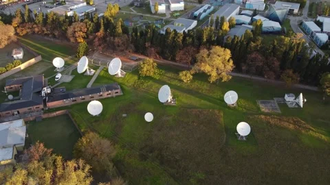 Circular drone shot at sunset of a meadow with parabolic satellite Stock Footage 200190750