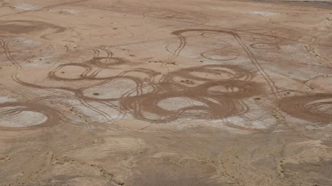 Circular erosion patterns on flat desert floor seen from Gara Medouar cliff Stock Footage 334513305