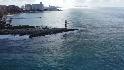 Circular flight of a drone over a red-white lighthouse on the shores of the sea Stock-Footage 201377343