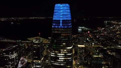 Circular footage of top section of Salesforce Tower at night. Modern high rise Stock Footage 240893143